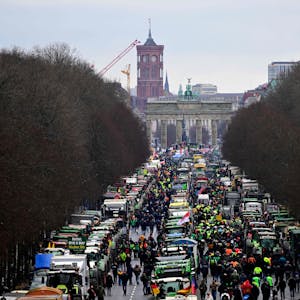 Traktoren und Lastwagen stehen vor dem Wahrzeichen Berlins, dem Brandenburger Tor. Im Hintergrund ist das Rote Rathaus der deutschen Hauptstadt zu sehen, während Landwirte und Lkw-Fahrer am 15. Januar 2024 in Berlin protestieren.