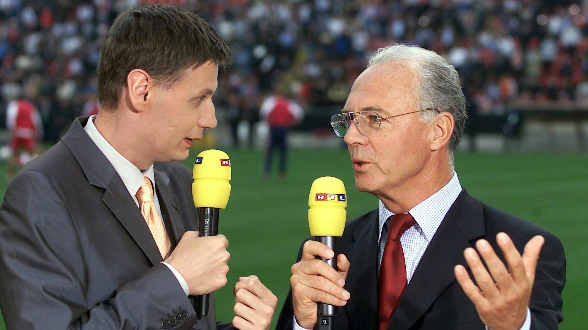 Günther Jauch (l.) und Franz Beckenbauer am 23. Mai 2001 vor dem Champions-League-Finale in Mailand mit RTL-Mikrofonen.