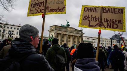 Demonstration von Landwirten am Montag in Berlin vor dem Brandenburger Tor: Demonstrationsteilnehmer zeigen Schilder mit der Aufschrift „Ist der Bauer ruiniert, wird das Essen importiert“ und „Ohne Bauern stirbt unser Land“.