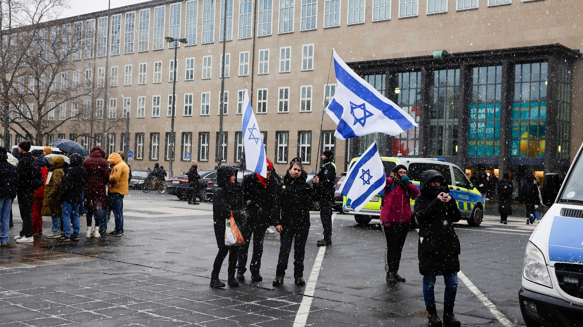 Menschen schwenken Israel-Flaggen bei einer Pro-Israel-Demo an der Universität Köln.