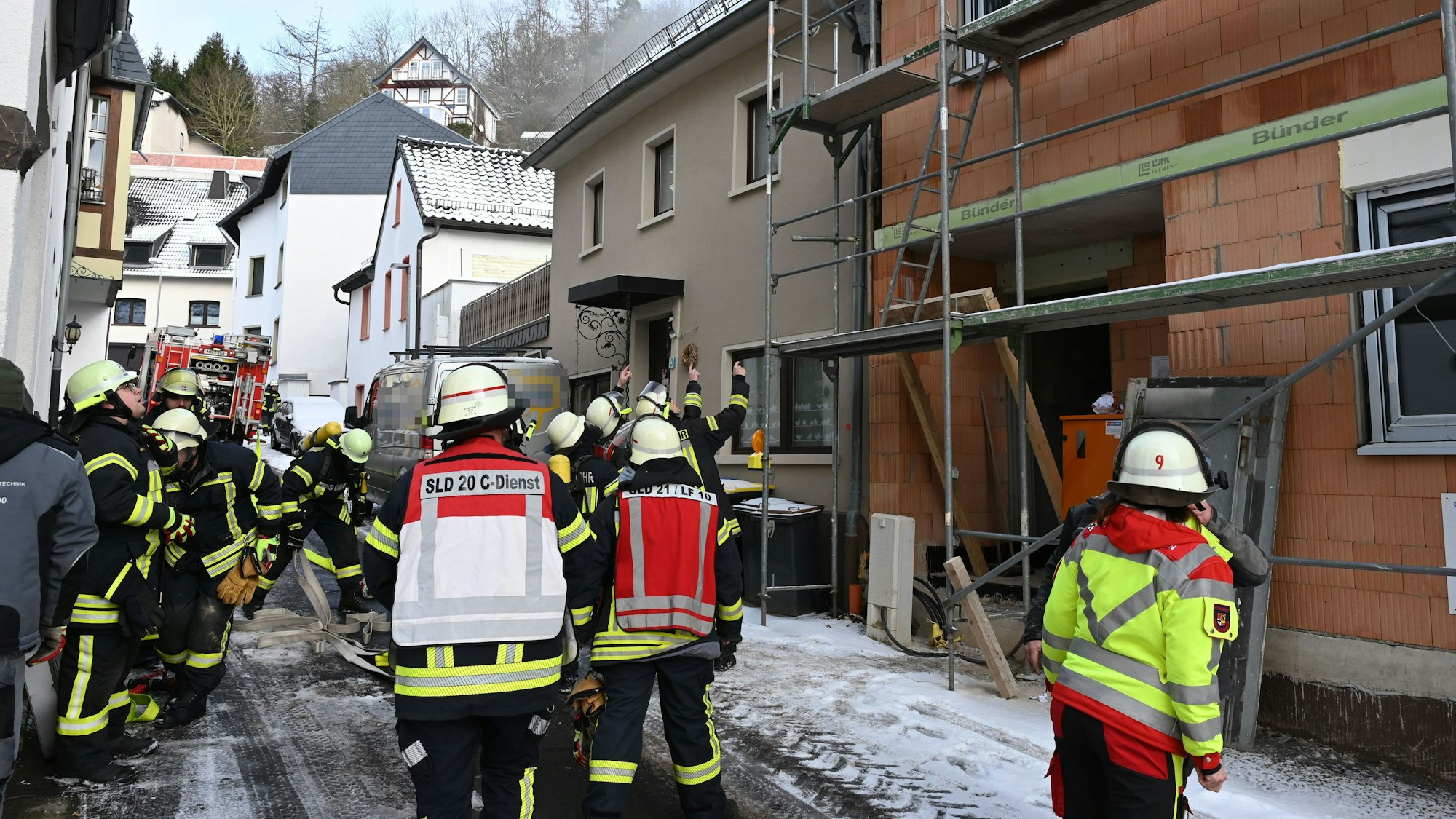 Zahlreiche Feuerwehrleute stehen vor zwei Häusern in Gemünd.