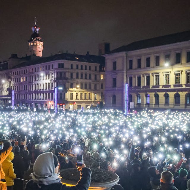 Leipzig: Zahlreiche Teilnehmer leuchten am Montagabend (15. Januar) mit den Taschenlampen ihrer Handys während einer Demonstration gegen die AfD.
