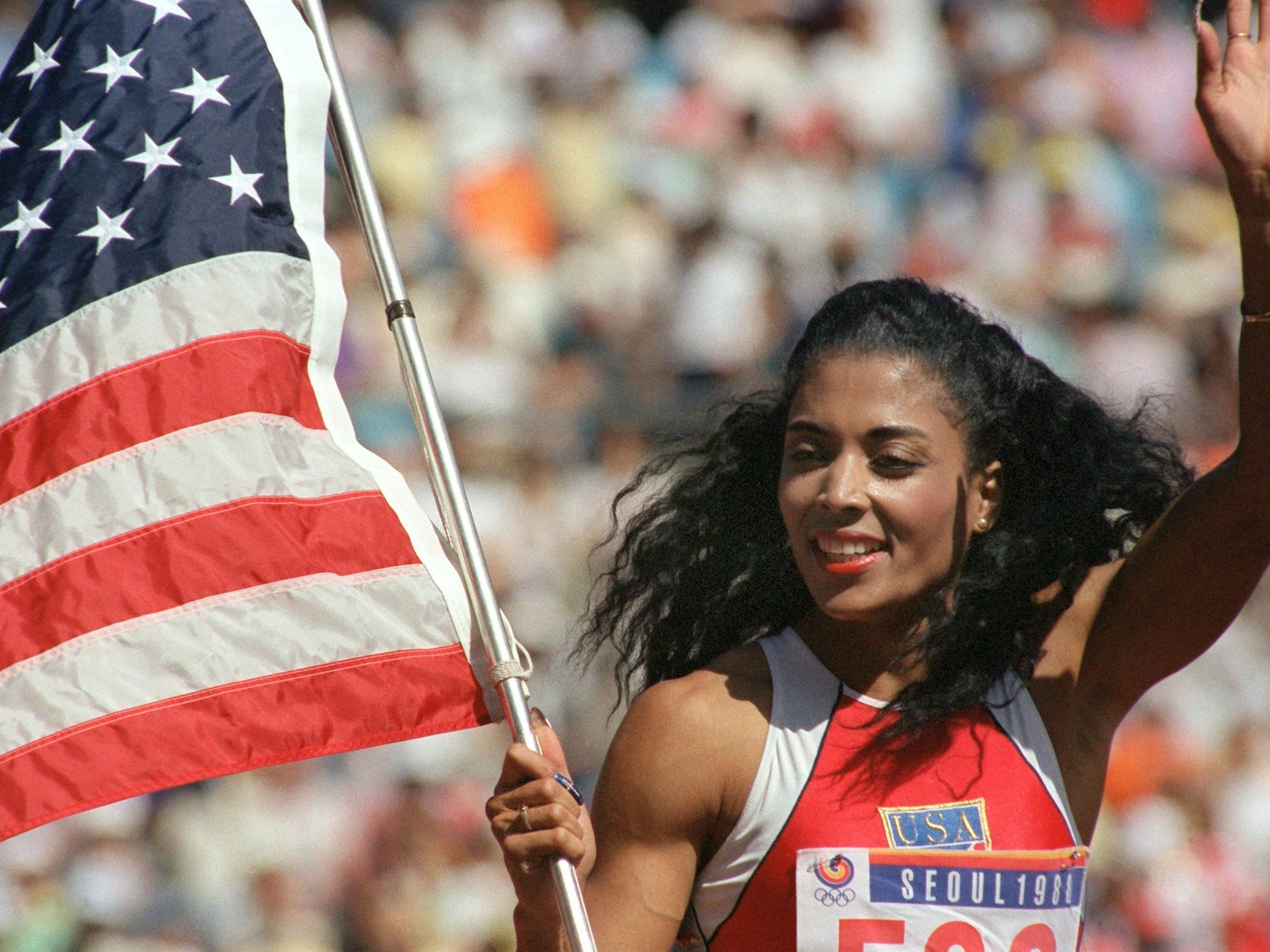 Die amerikanische Sprinterin Florence Griffith-Joyner präsentiert sich stolz und glücklich mit Flagge, nachdem sie bei den Olympischen Sommerspielen in Seoul im 100-m-Lauf der Frauen die Goldmedaille errungen hat.