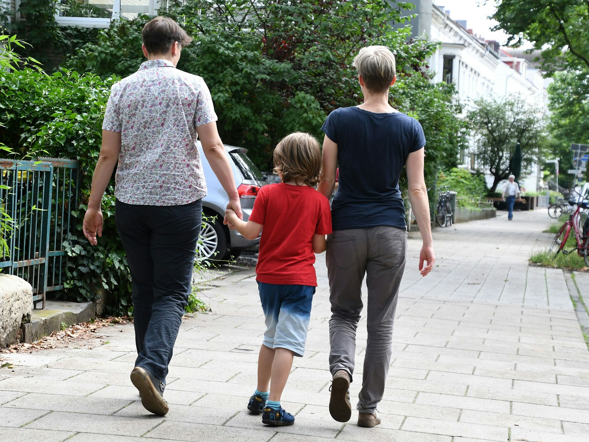 Ein miteinander verheiratetes lesbisches Paar geht in Bremen mit seinem Sohn spazieren.
