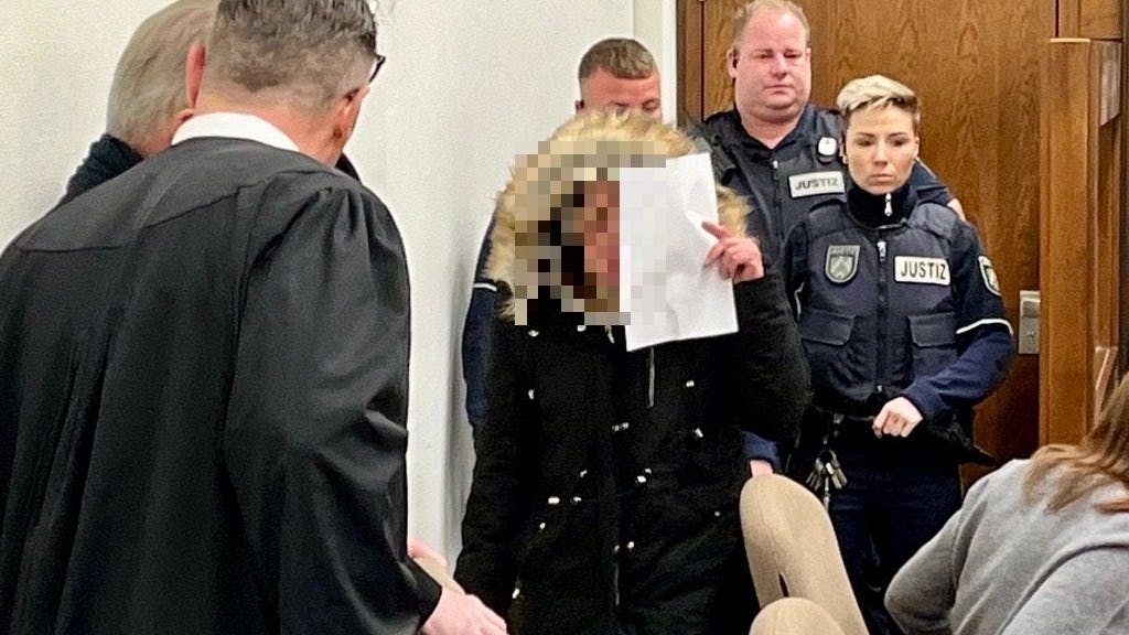 Eine Frau kommt vermummt zu einer Verhandlung im Kölner Landgericht.