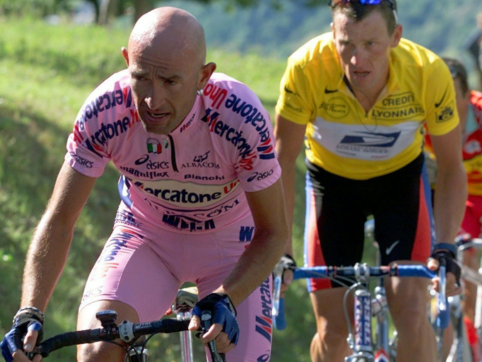 Der italienische Radprofi Marco Pantani (r) und der US-Amerikaner Lance Armstrong im Gelben Trikot des Spitzenreiters fahren einen Berg hoch.