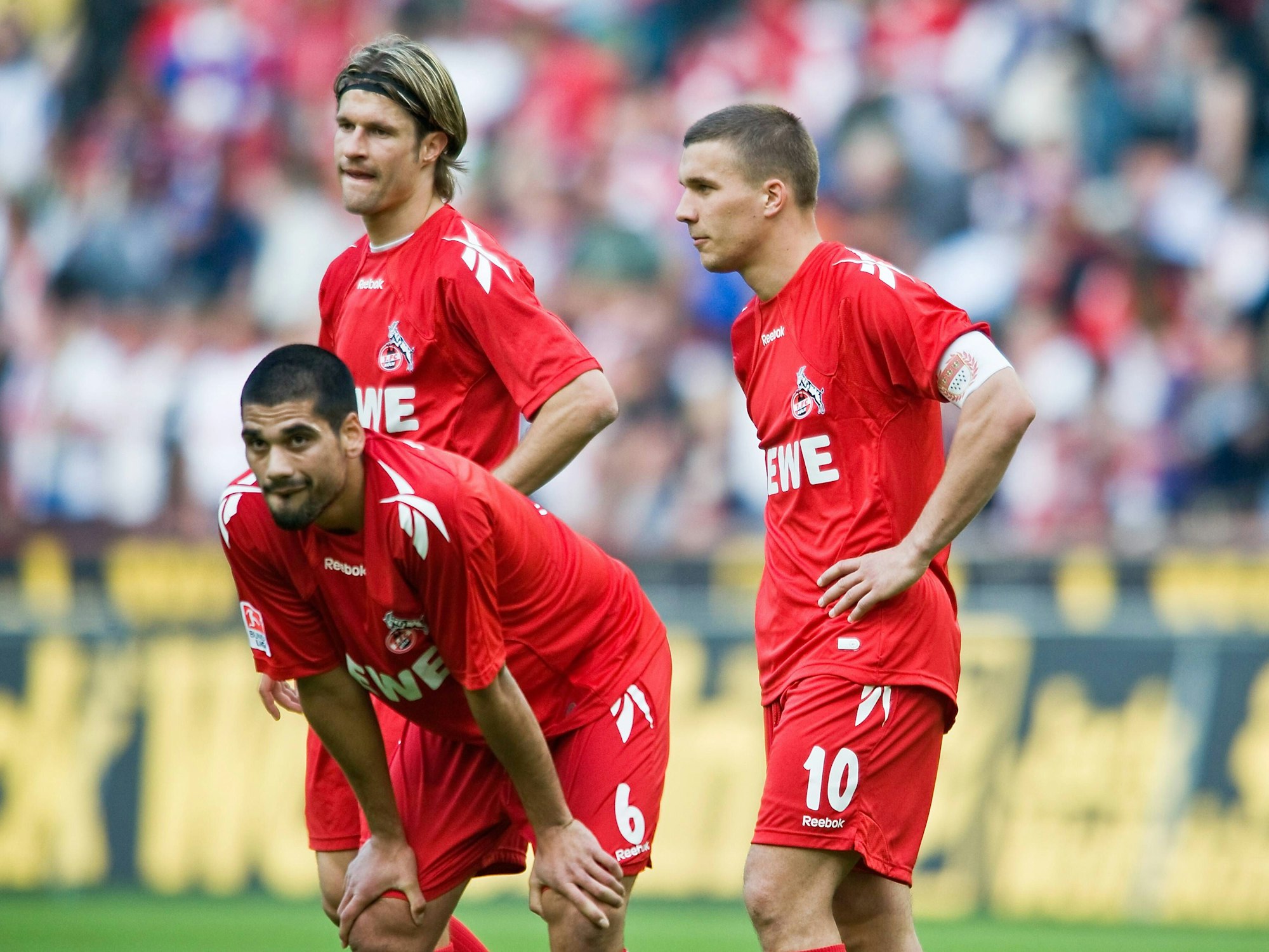 Taner Yalcin, Lukas Podolski und Martin Lanig stehen nach einer Niederlage des 1. FC Köln auf dem Rasen.