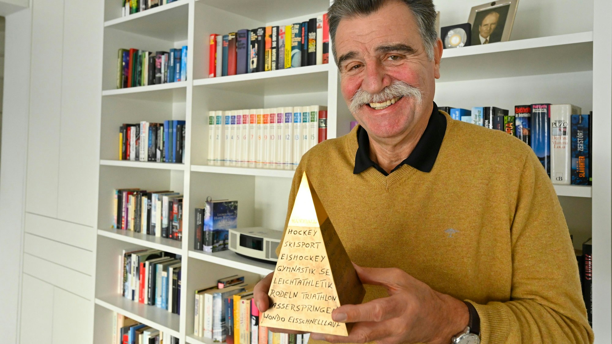 Heiner Brand hält die goldene Sportpyramide in den Händen.