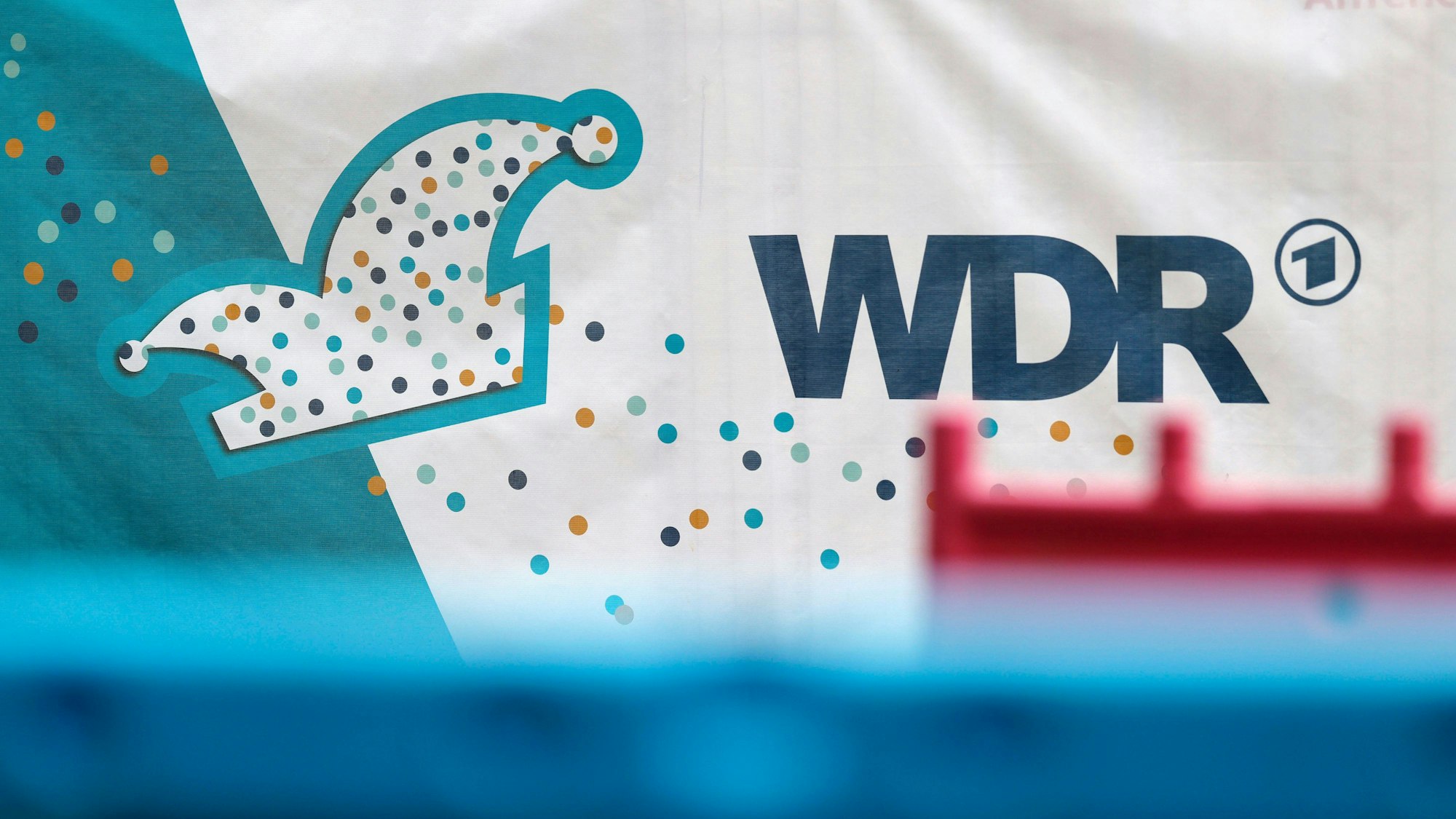Ein WDR-Logo auf einem Absperrungszaun.