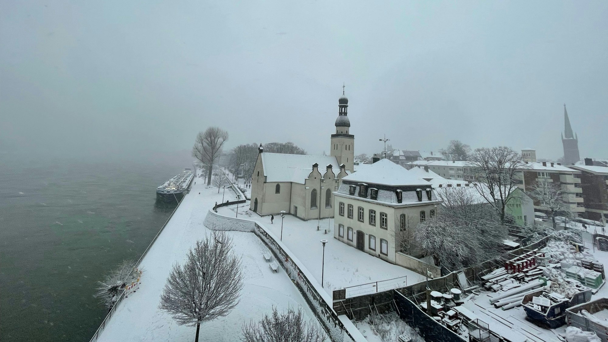 Schneebedeckte Gebäude am Rheinufer