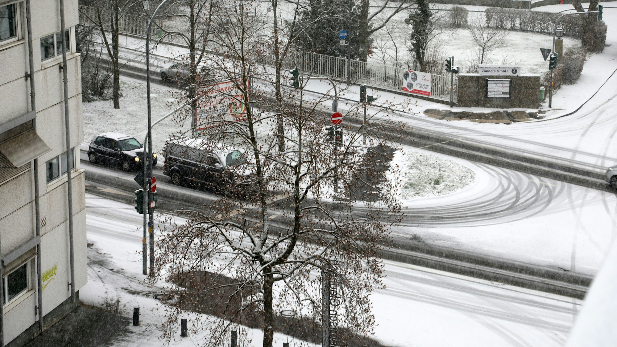 Auf der Kreuzung Poststraße/An der Gohrsmühle in Bergisch Gladbach sind im frischen Schnee Fahrspuren zu sehen.