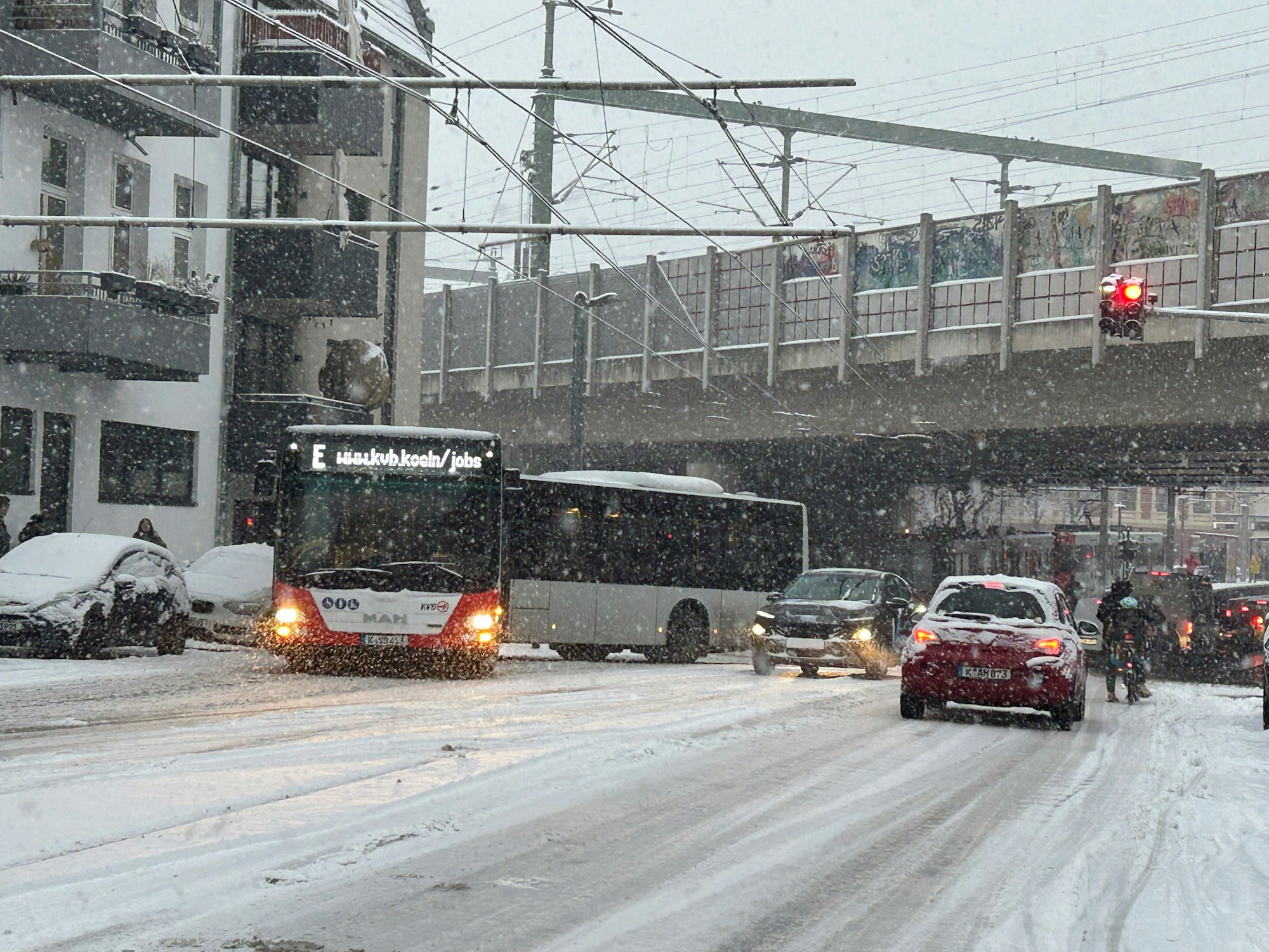 Zu sehen ist eine befahrene Straße, ein Bus steht darauf und es liegt Schnee.