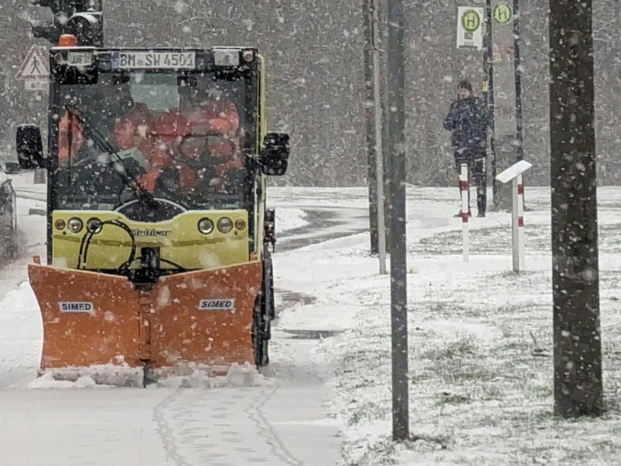 Ein Schneepflug befreit den Rad- und Fußweg an der Horbeller Straße in Hermülheim von erstem Schnee.