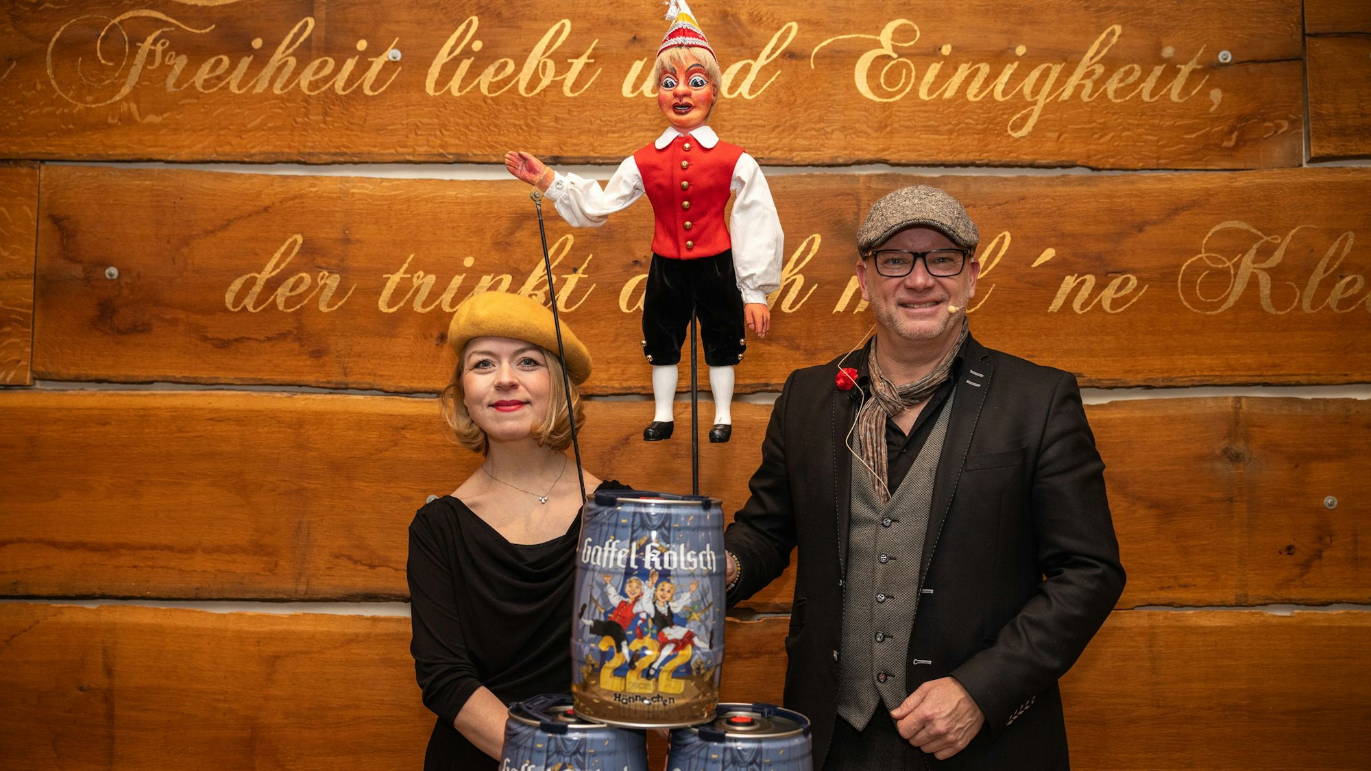 Ein Mann und eine Frau mit drei Gaffel-Fässchen und einer Hänneschen-Puppe