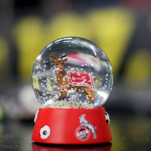 Eine Schneekugel mit dem Vereinslogo des 1. FC Köln und Maskottchen Hennes im Inneren.