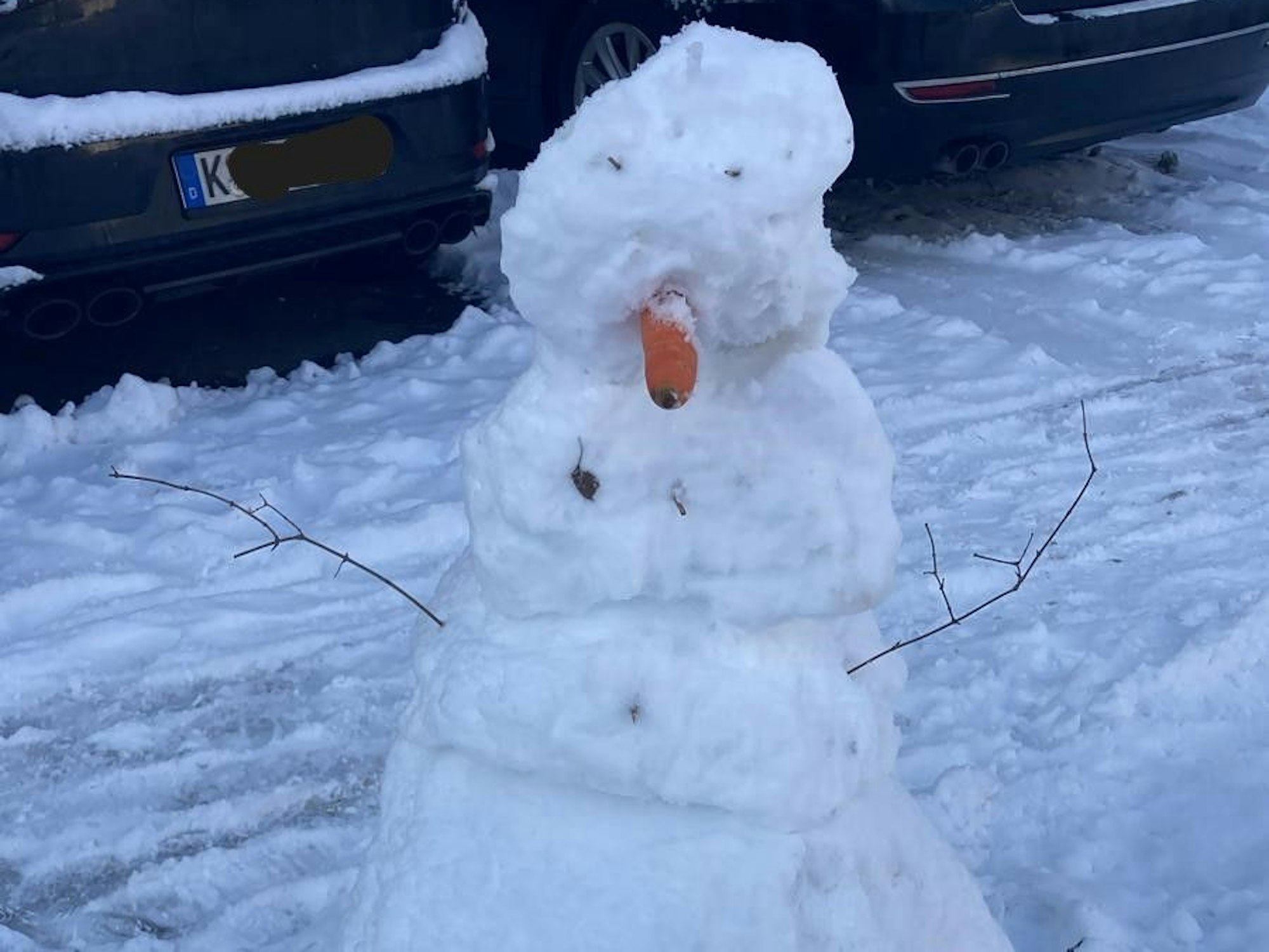 Ein Schneemann auf einem Parkplatz.