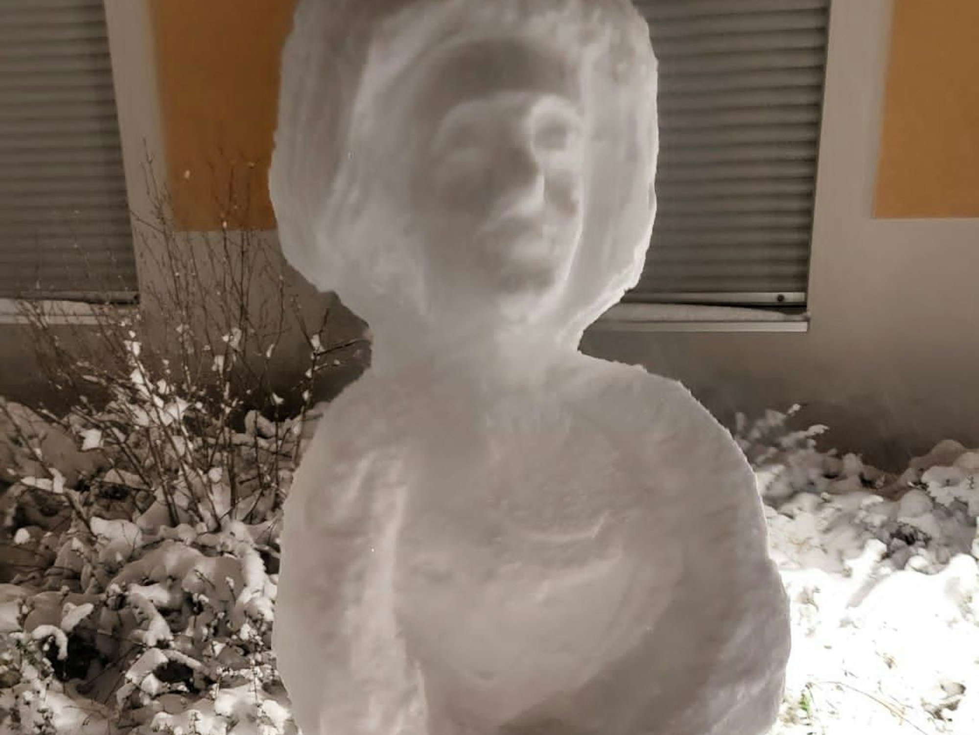 Eine Skulptur aus Schnee vor einem Haus.