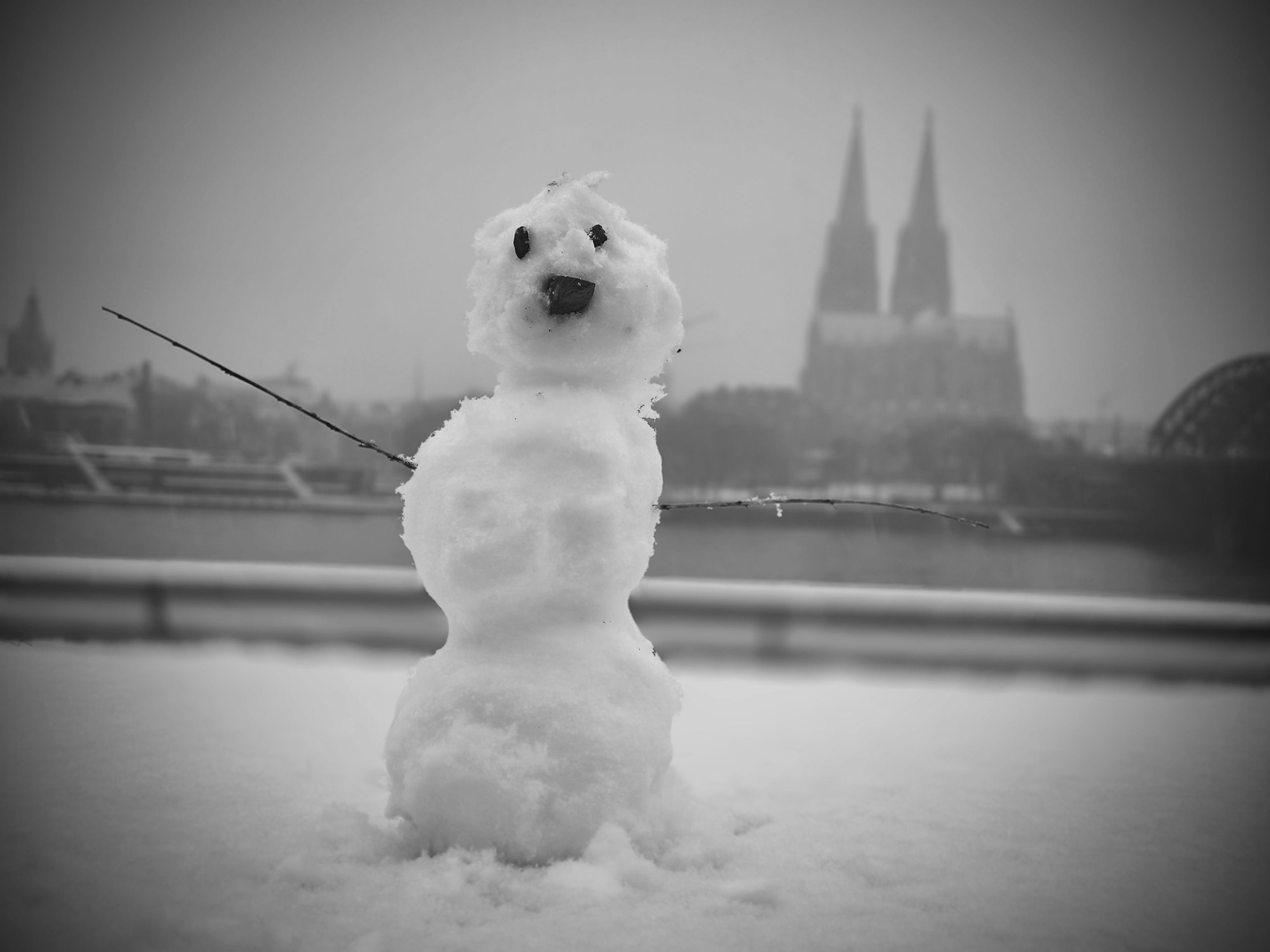 Ein Schneemann steht am Rheinufer in Köln.