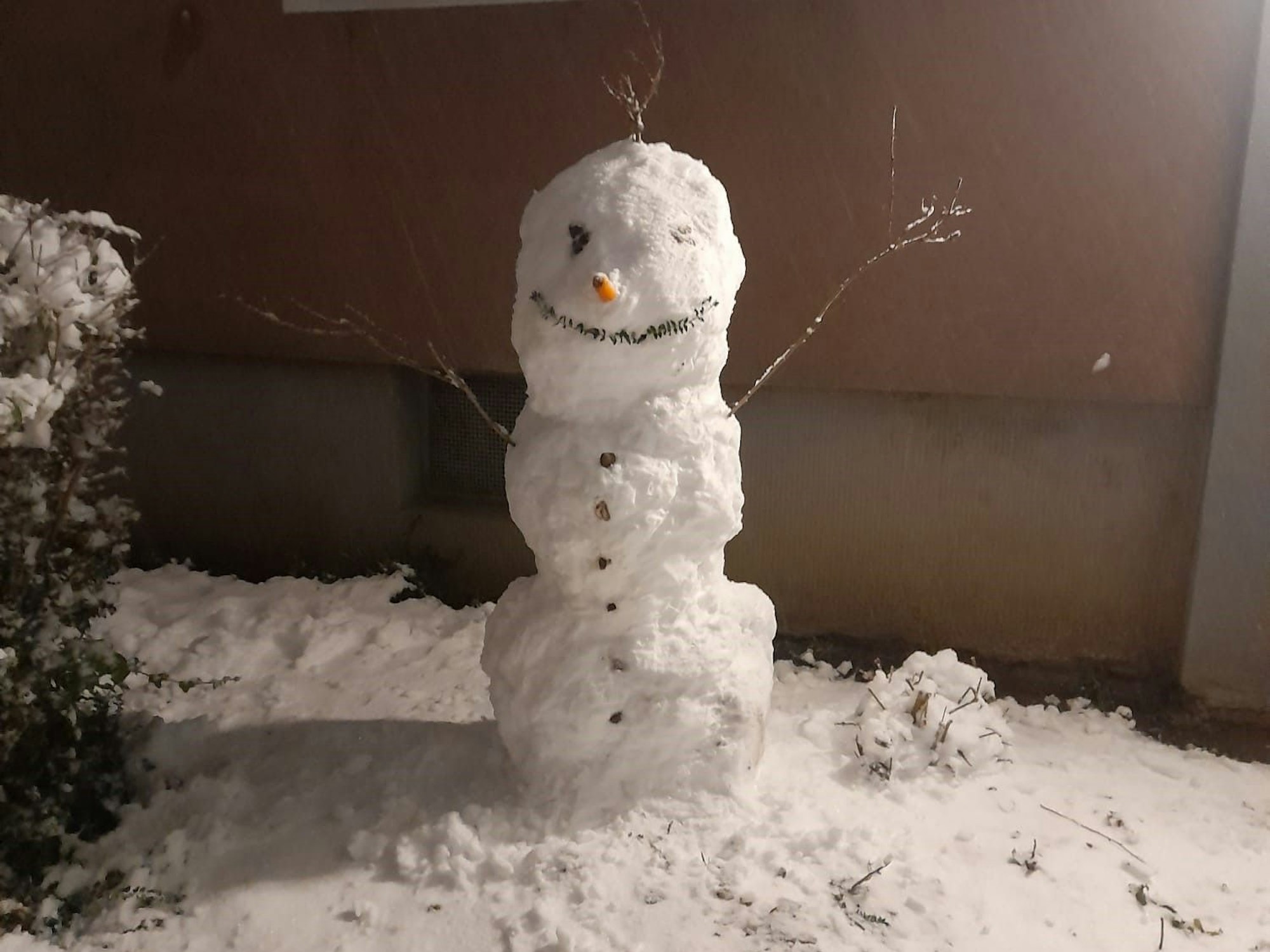 Ein Schneemann vor dem Haus.