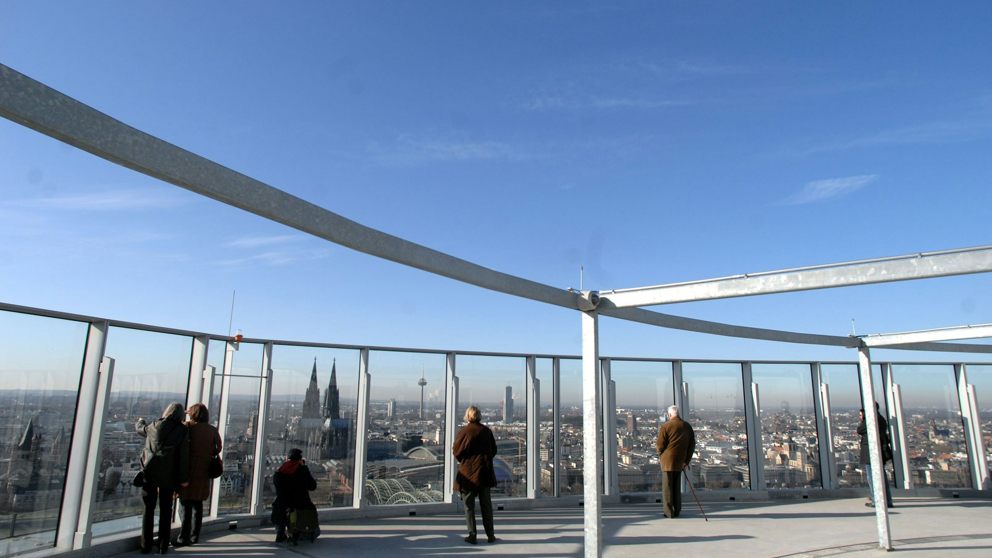 Menschen stehen an den Fenstern der Aussichtsplattform „Cologne View“.