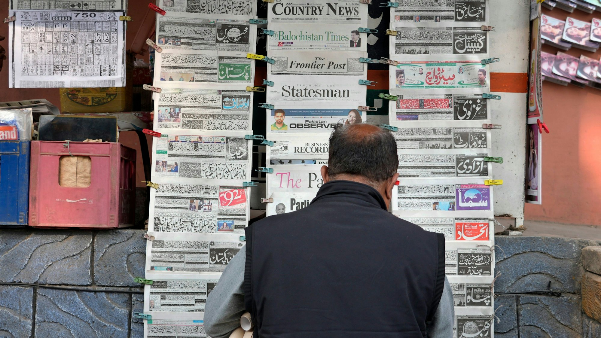 Ein Pakistaner liest an einem Verkaufsstand Tageszeitungen, die auf der Titelseite über den iranischen Angriff berichten.