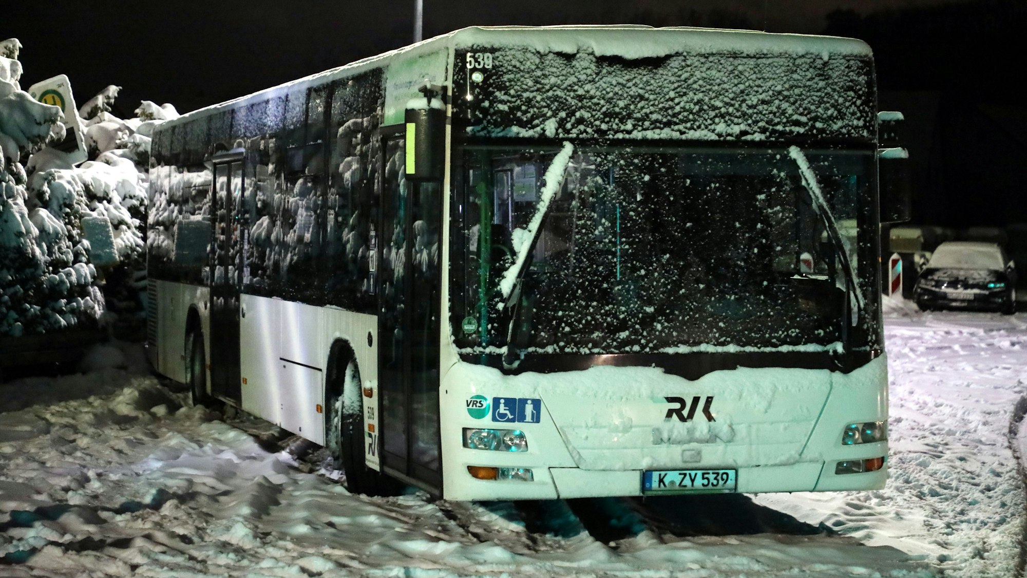 Ein eingeschneiter Bus steht in Overath-Heiligenhaus quer auf der Straße,