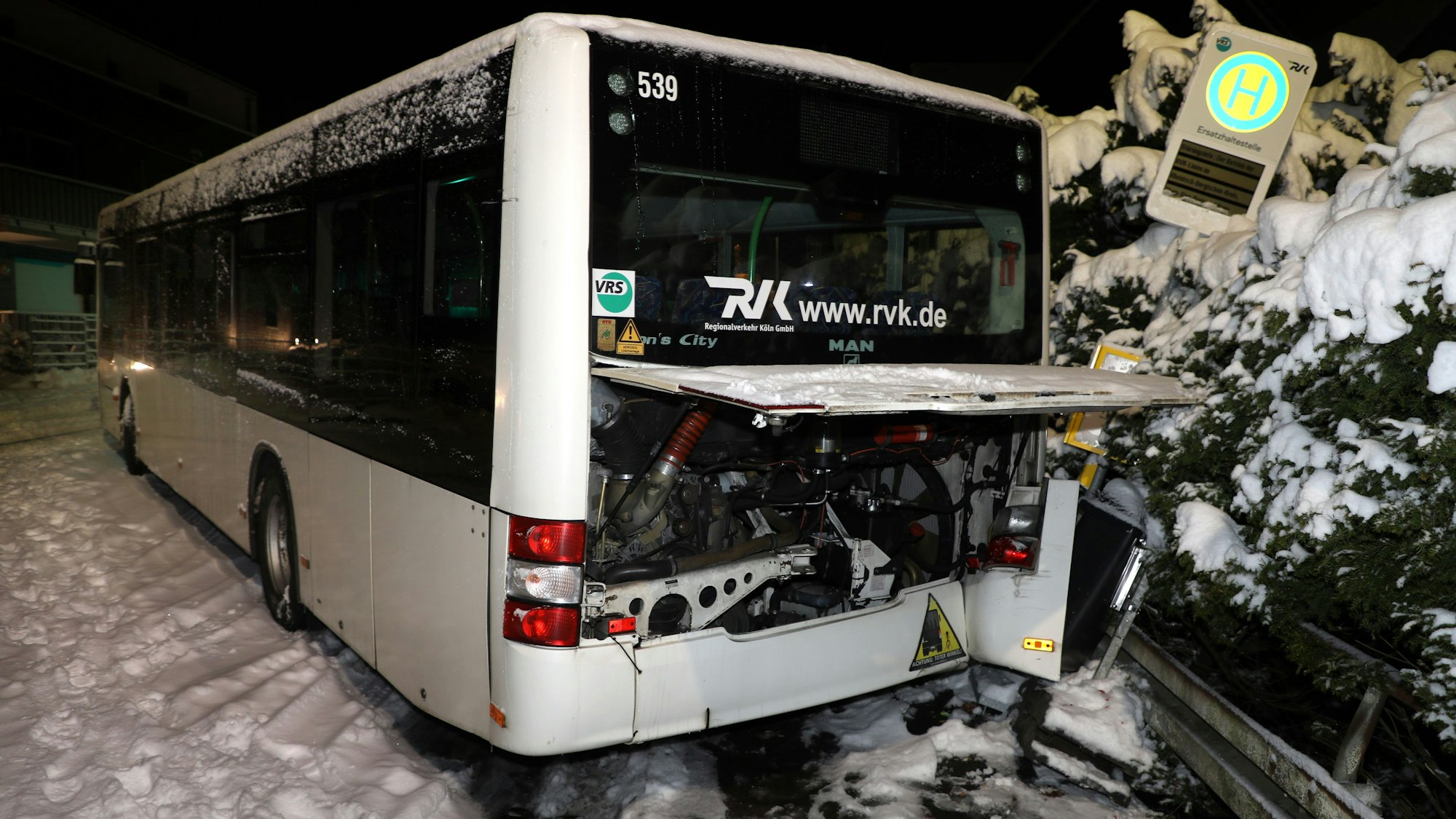 Ein Bus mit demoliertem Heck und Kotflügel steht neben einem umgekippten Bushaltestellen-Schild.