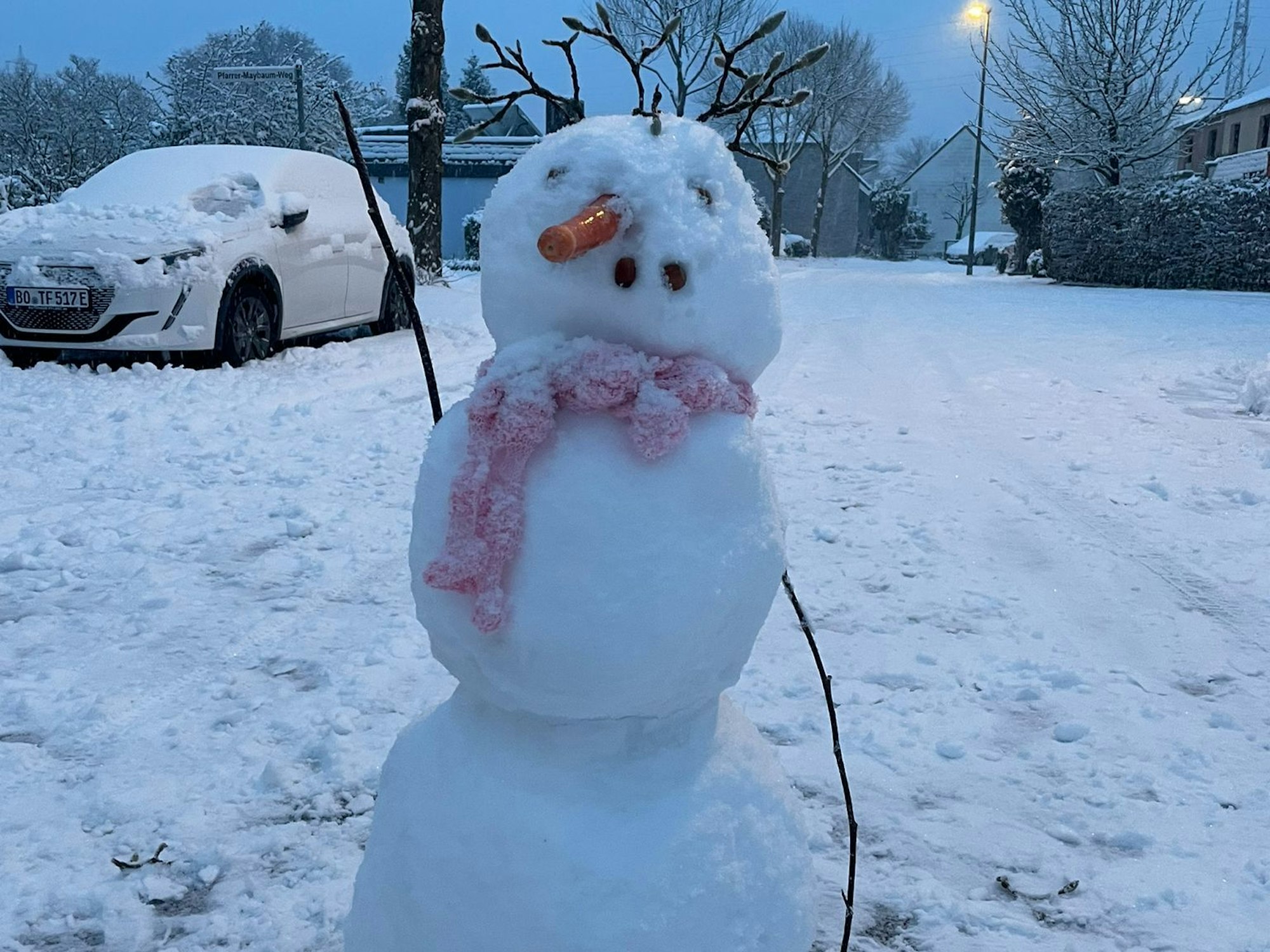 Ein Schneemann auf einem Parkplatz.