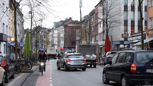 Autos und eine Fahrradfahrerin fahren über die Venloer Straße.
