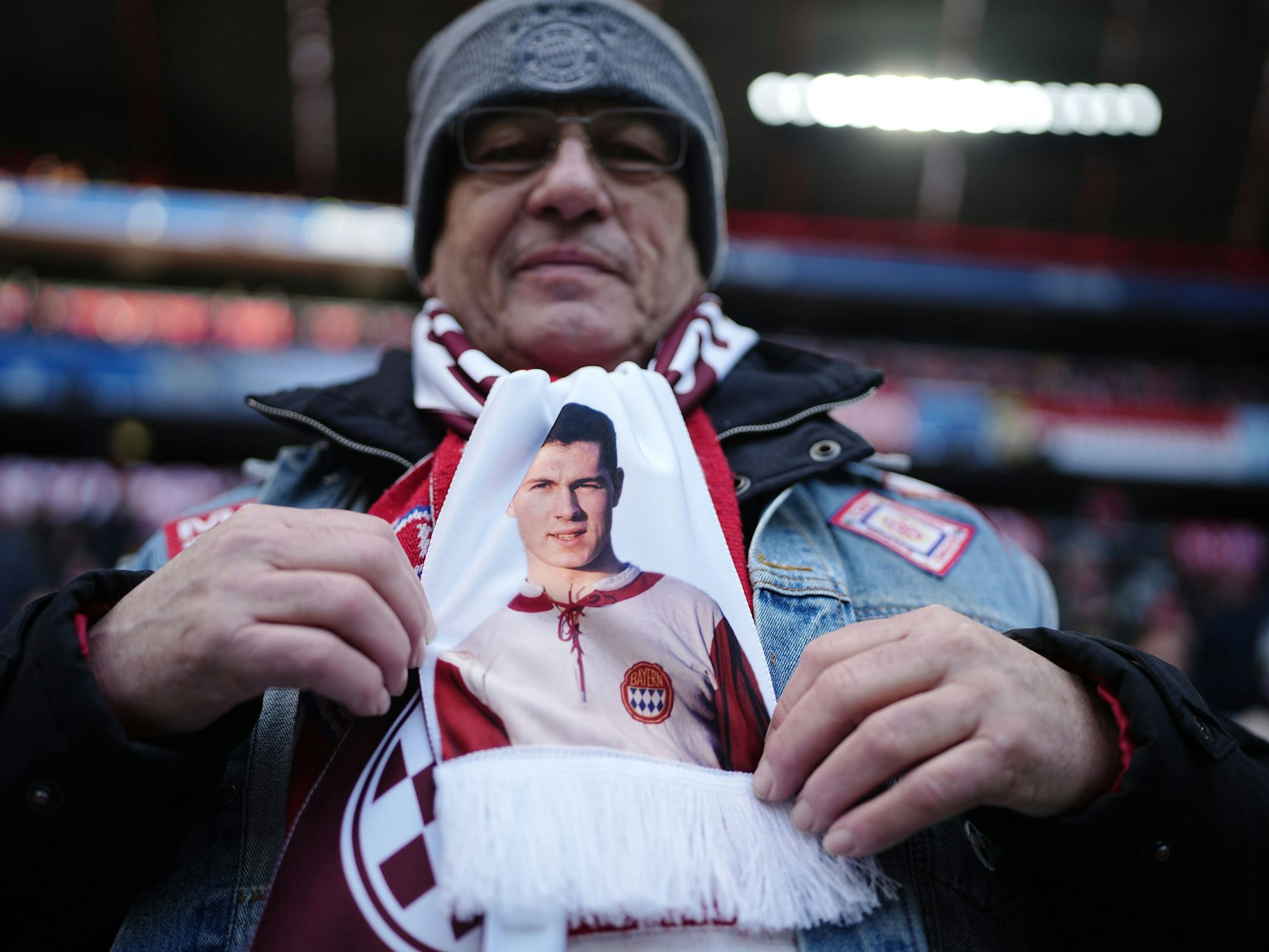 Ein Bayern-Fan trägt einen Schal mit einem Bild des jungen Franz Beckenbauer.
