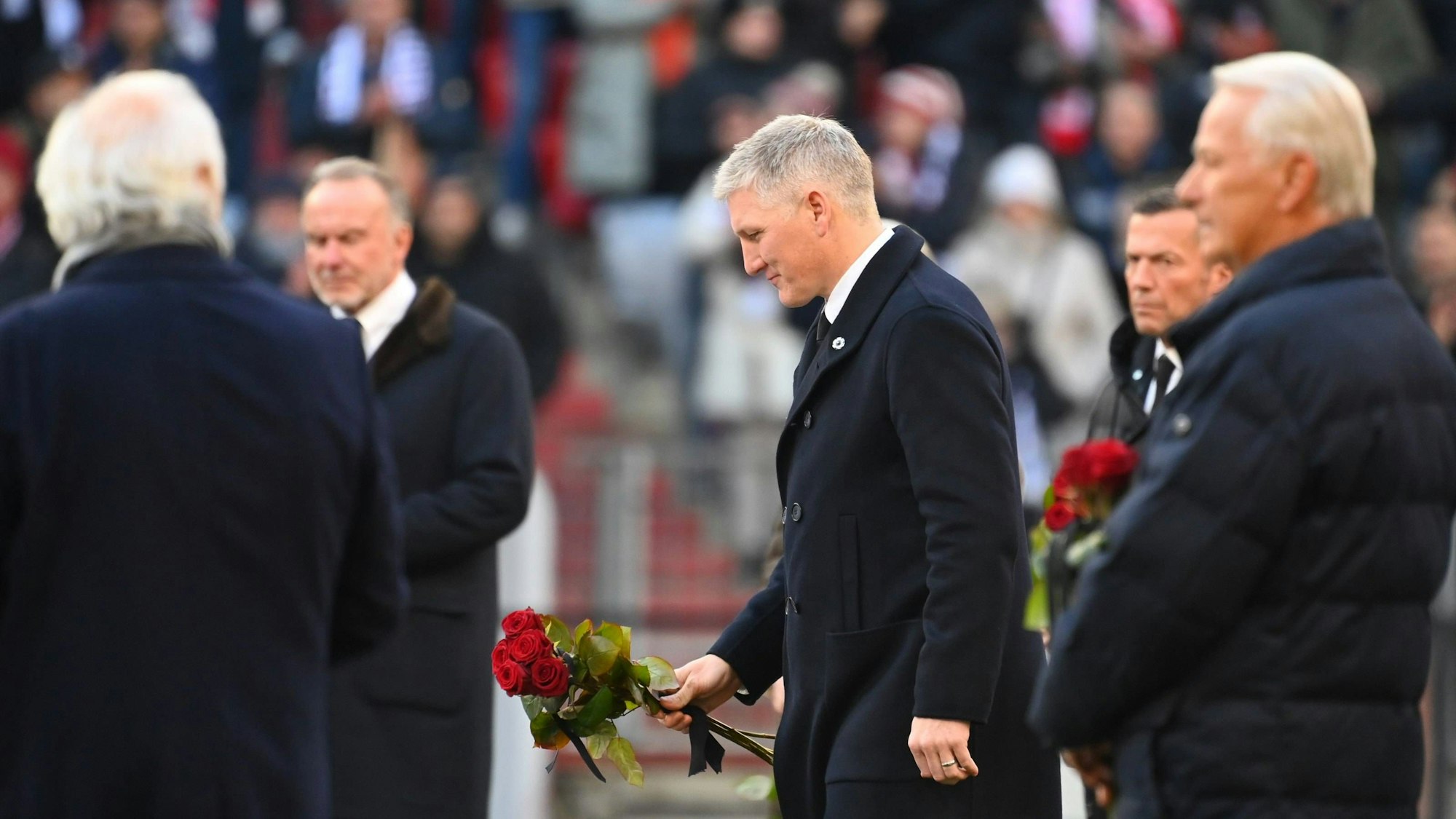 Bastian Schweinsteiger legt bei der Trauerfeier für Franz Beckenbauer Rosen nieder.