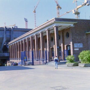 Vor dem Marathontor des Müngersdorfer Stadions ist ein geöffnetes blaues Eisentor zu sehen. An Spieltagen verwehrt es den Stadionbesuchern den Zugang zum Innenraum der Arena.