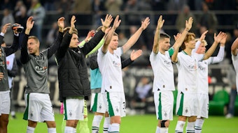 Borussia-Spieler heben die Arme.