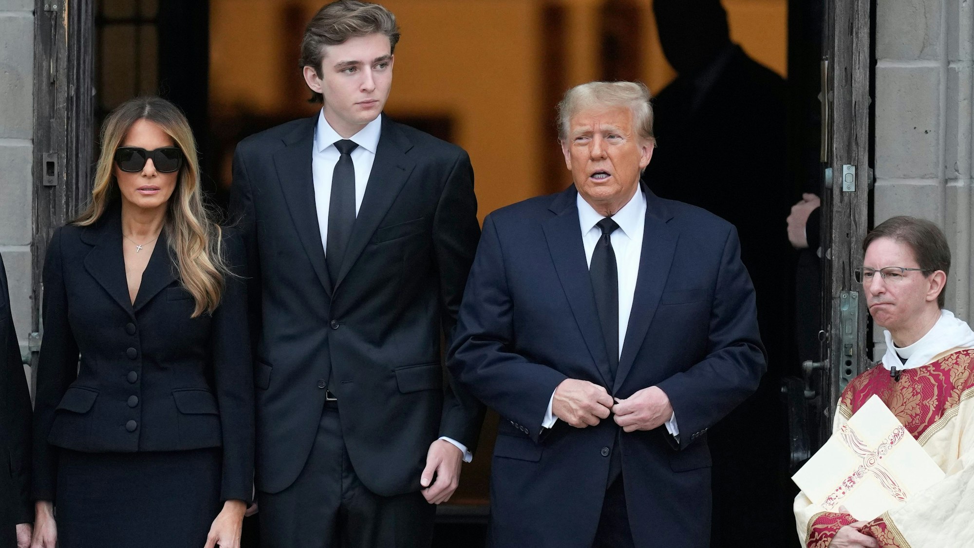 Donald Trump (2.v.r), ehemaliger Präsident der USA, steht mit Melania Trump (l.), ehemalige First Lady, und ihrem Sohn Barron Trump bei der Beerdigung von Amalija Knavs, Mutter von Melania Trump, vor der Kirche Bethesda-by-the-Sea.