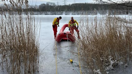 Ein Eisrettungsboot mit zwei Feuerwehrleuten auf dem zugefrorenen Otto-Maigler-See.