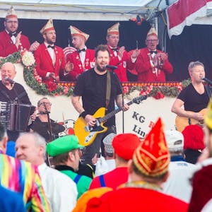 Eine Karnevalsband auf der Bühne, dahinter der Elferrat, vorn Zuschauer.