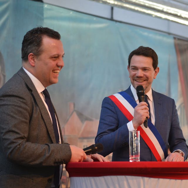 Die beiden Bürgermeister am Rednerpult. Der französische Bürgermeister trägt eine Schärpe in den französischen Nationalfarben.&nbsp;