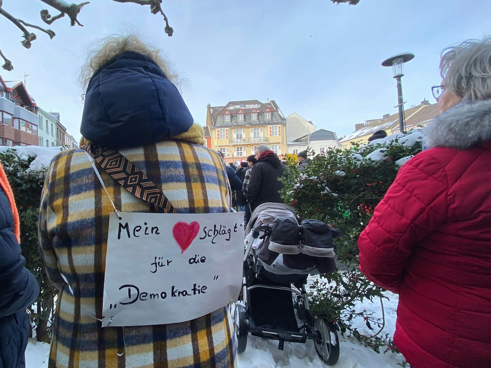 „Mein Herz schlägt für die Demokratie“ steht auf dem Schild, das eine Frau auf dem Rücken trägt.