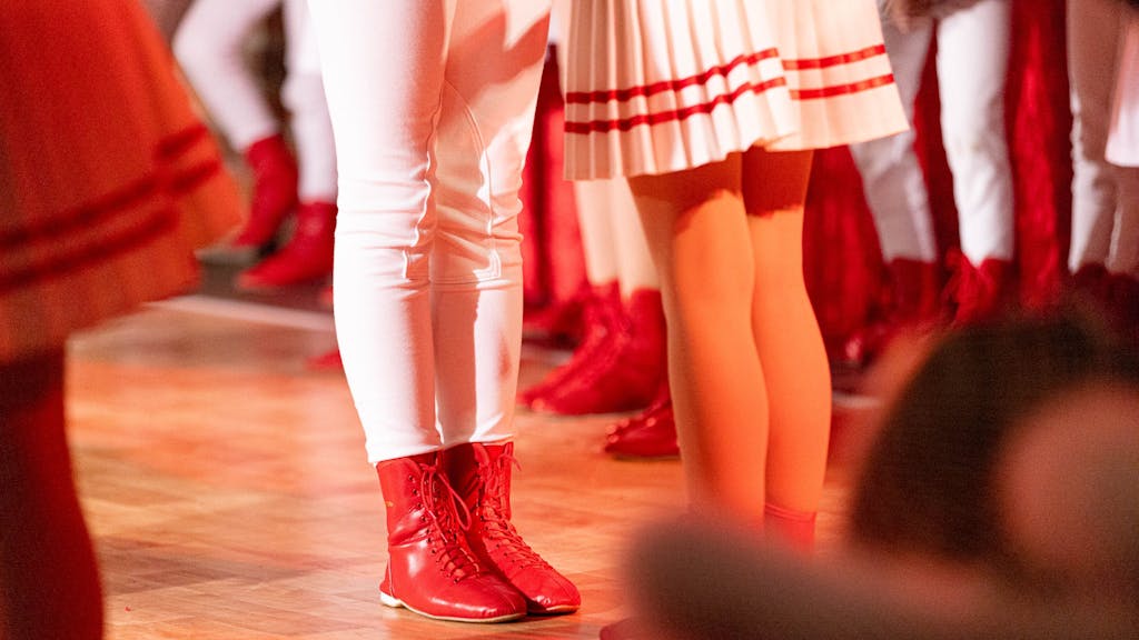 Die Füße eines Tänzers und einer Tänzerin sind auf der Bühne einer Karnevalssitzung zu sehen.