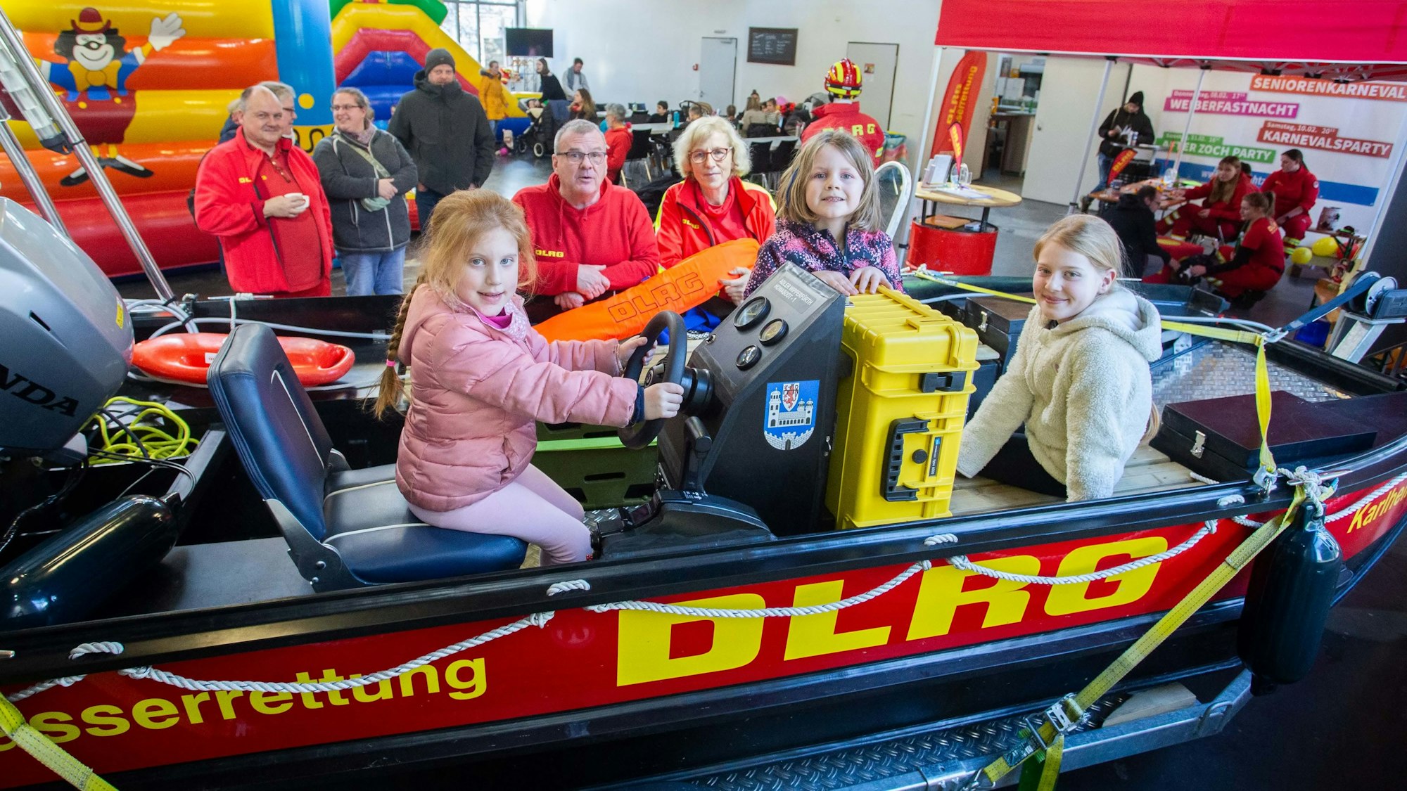 Das Foto zeigt das Rettungsboot der DLRG Wipperfürth mit drei Kindern und Ehrenamtlern der DLRG im Hintergrund.