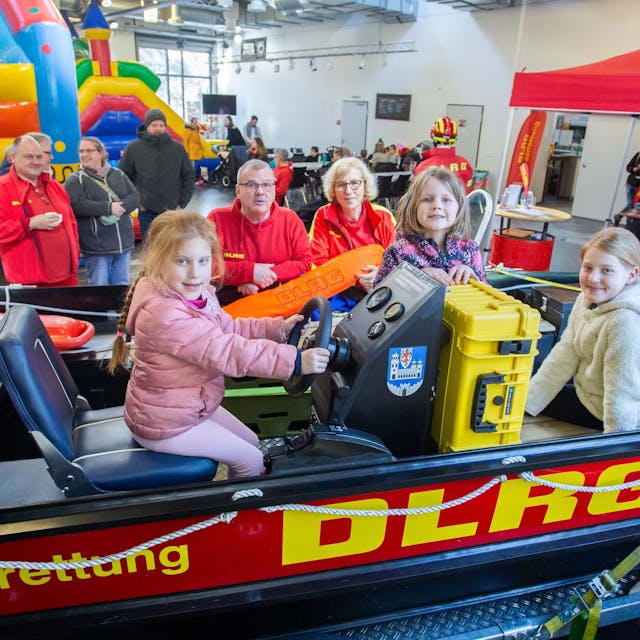 Das Foto zeigt das Rettungsboot der DLRG Wipperfürth&nbsp; mit drei Kindern und Ehrenamtlern der DLRG im Hintergrund.&nbsp;