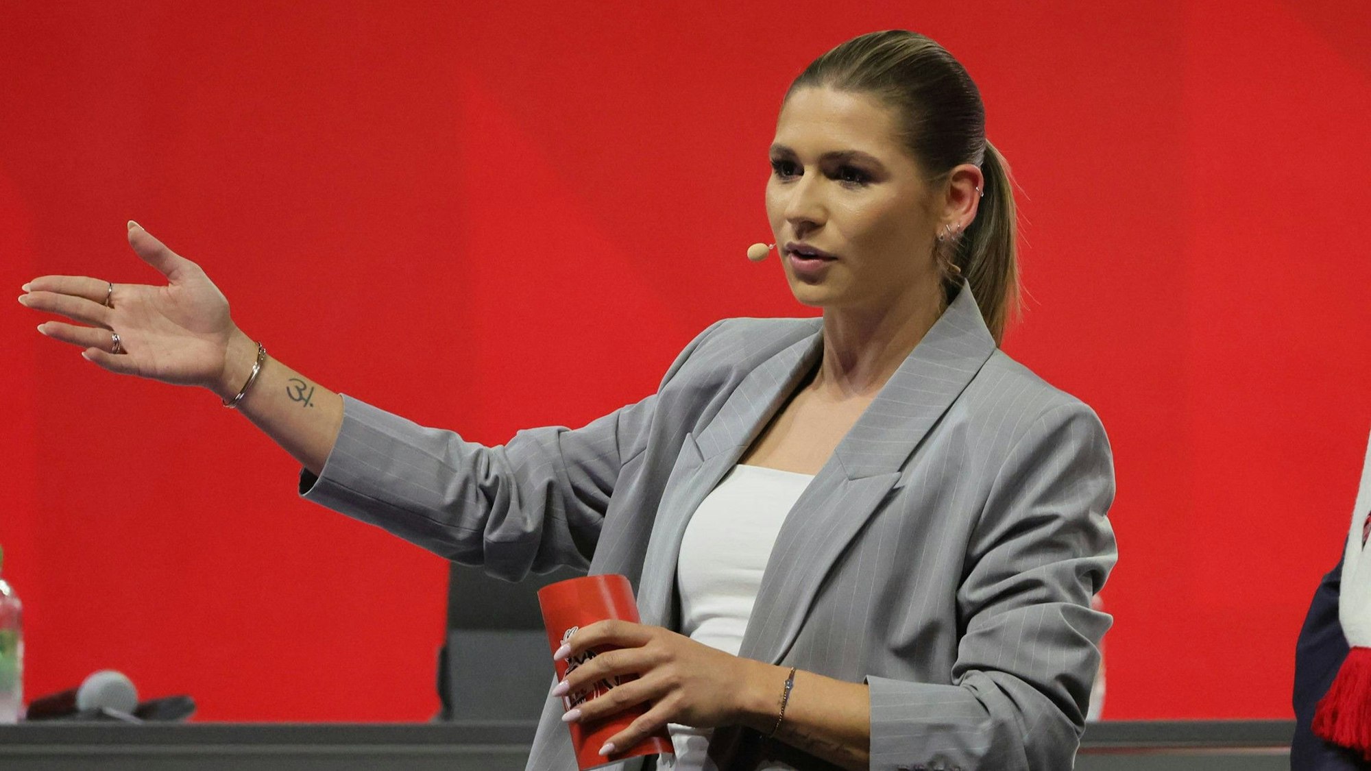 Jana Wosnitza gestikuliert als Moderatorin der Mitgliederversammlung des 1. FC Köln.