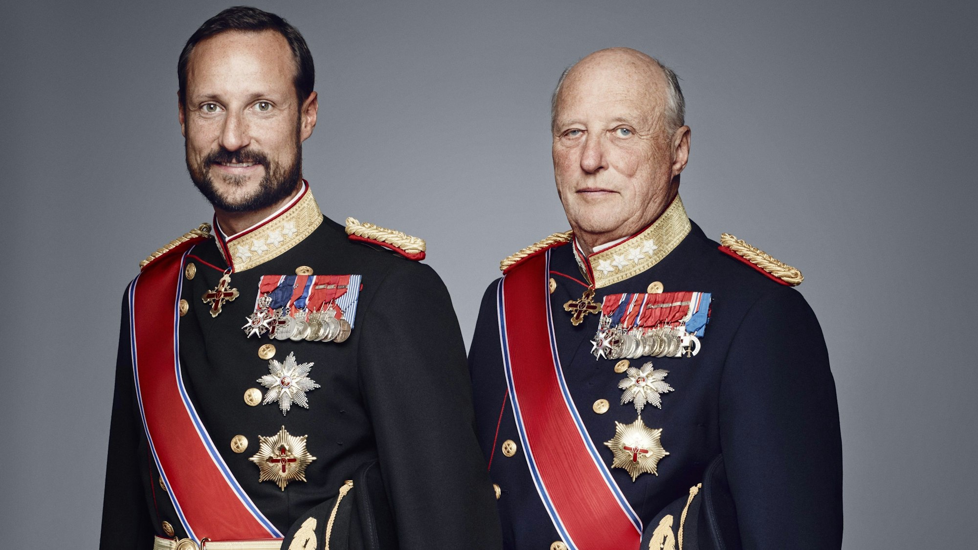 Kronprinz Haakon (l) und König Harald V. (r) auf einem offiziellen Porträtfoto.