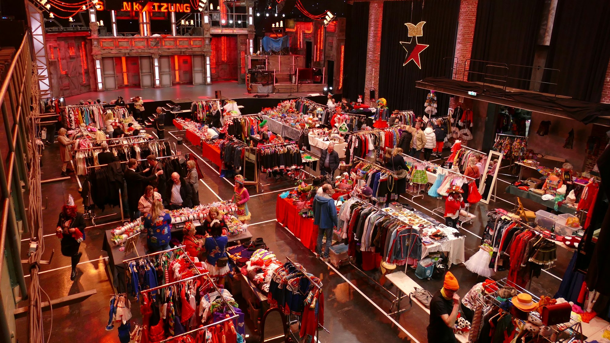 Ein Flohmarkt mit Kostümen in einer Veranstaltungshalle.