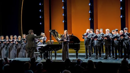 Das Foto zeigt den Chor der Kölner Oper unter der Leitung von Rustam Samedov und Solistin Maria Möller.