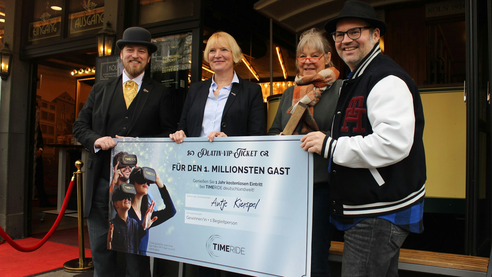 Zwei Männer und drei Frauen vor einem Check mit der Aufschrift „für den 1. Millionsten Gast“