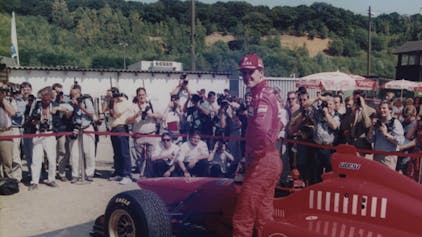 Auf dem Foto ist Michael Schumacher vor seinem roten Ferrari bei einem Termin 1996 in Kerpen zu sehen.