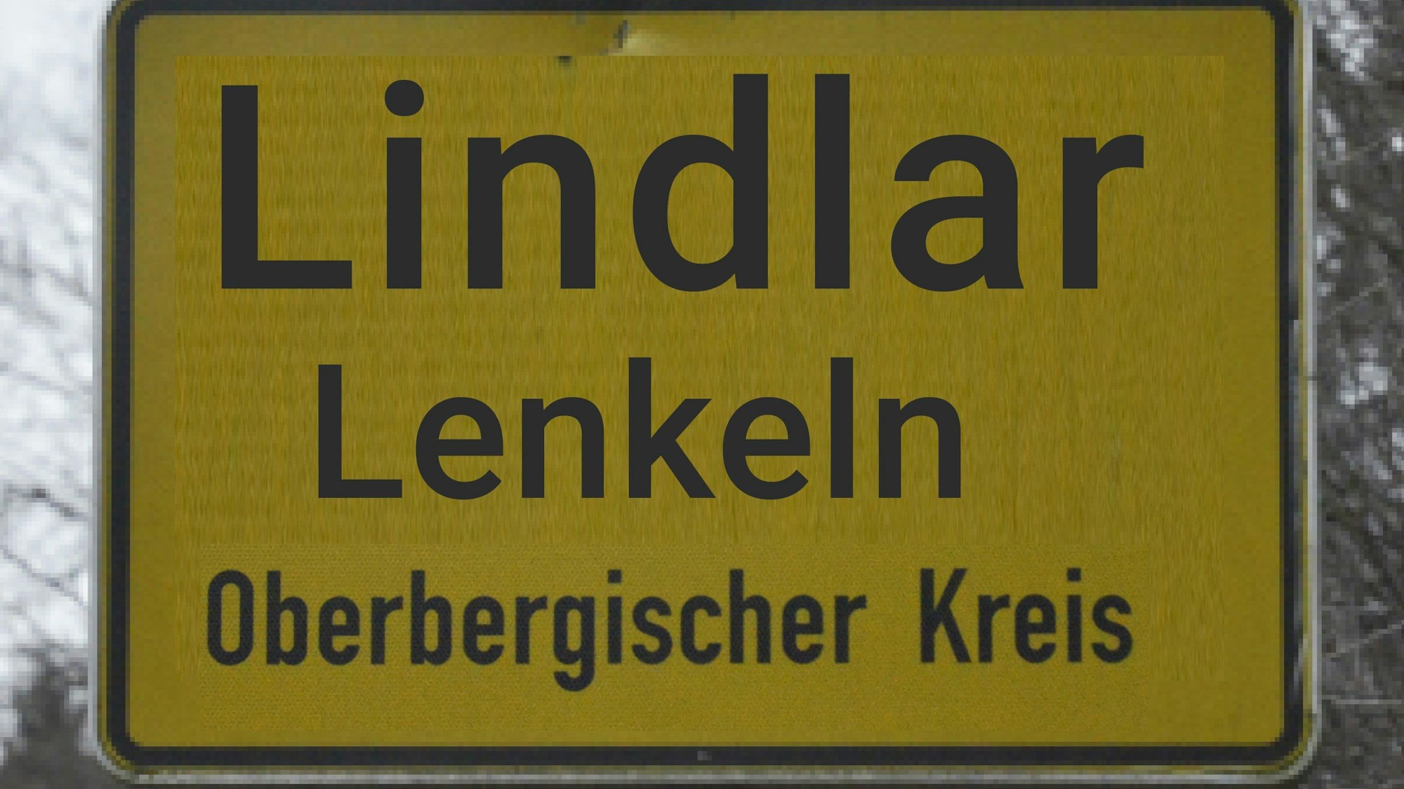 Bildmontage Lindlar Ortsschild mit Zusatz des Namens in Mundart.