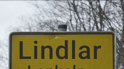 Bildmontage Lindlar Ortsschild mit Zusatz des Namens in Mundart.