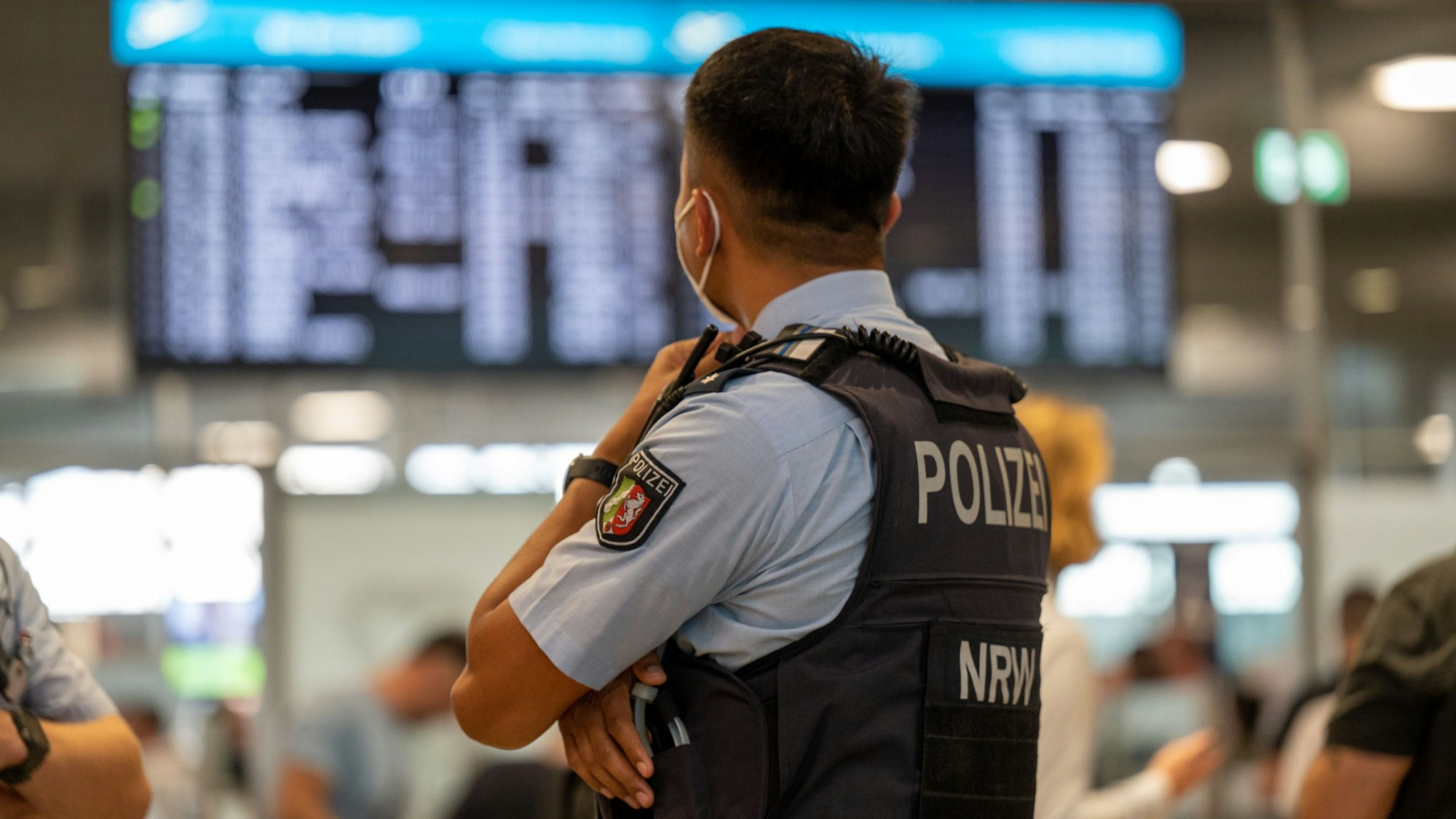 Ein Polizist der Landespolizei NRW steht im Flughafen Köln/Bonn.